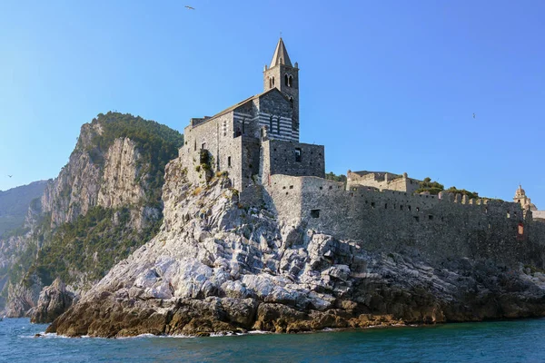 Sint-Pieterskerk (Chiesa di San Pietro) tegen de heldere blauwe hemel met grote kopie ruimte, beroemde bezienswaardigheid in Porto Venere, het kustplaatsje aan de Golf van dichters tussen La Spezia en Cinque Terre, Ligurië, Italië — Stockfoto