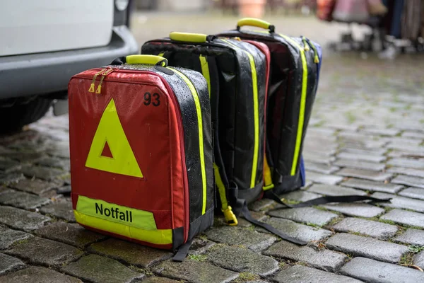 Emergency cases of the mobile ambulance on cobblestone pavement in the rain at a large event in the city — Stock Photo, Image