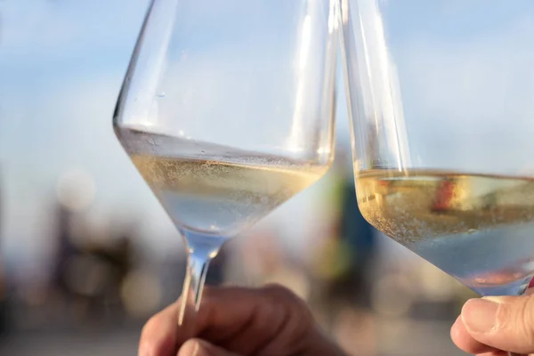 Tosty z zimnym białym winem w słoneczny letni wieczór podczas wakacji, koncepcja przyjemności i stylu życia, zbliżenie — Zdjęcie stockowe