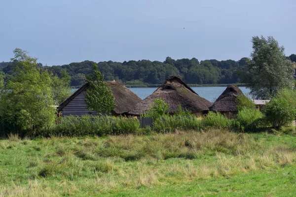 Casas históricas con techo de paja en el pueblo vikingo de Hedeby a orillas del río Schlei en el norte de Alemania, espacio para copias — Foto de Stock