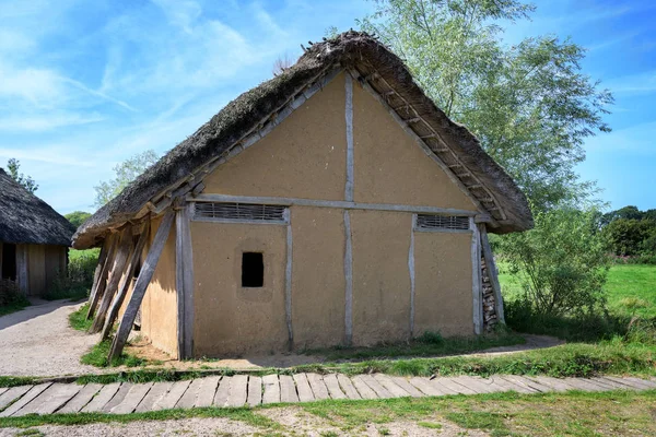 Casa histórica de entramado de madera con yeso franco y techo de paja en el pueblo vikingo reconstruido Hedeby a orillas de la ensenada Schlei del Mar Báltico en el norte de Alemania, cielo azul, espacio para copias — Foto de Stock