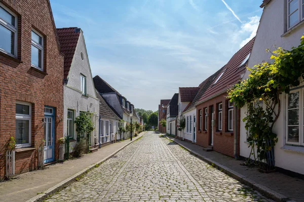 Straße mit niedrigen Häusern, Kopfsteinpflaster und Rosen in friedrichstadt, dem von holländischen Siedlern gegründeten schönen Ort und Reiseziel in Norddeutschland, Kopierraum — Stockfoto