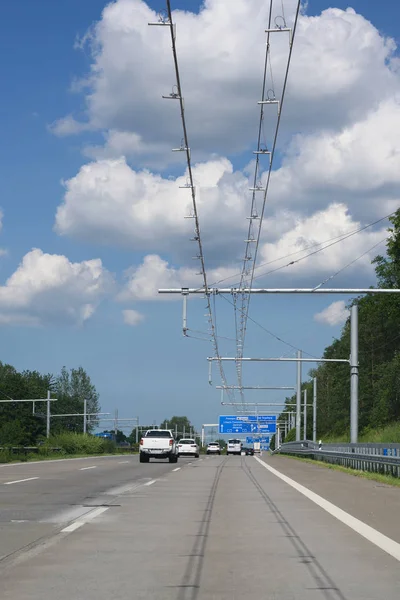 E-αυτοκινητόδρομος με ηλεκτρικά εναέρια σύρμα επαφής για υβριδικά φορτηγά, πίστα δοκιμών στο Luebeck, Γερμανία, μπλε ουρανό με σύννεφα, κενό χώρο, κάθετη — Φωτογραφία Αρχείου