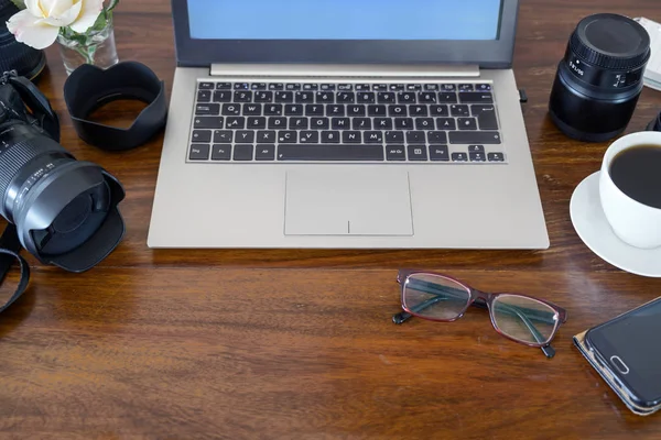 Escritorio de madera de un fotógrafo con portátil, cámara, lentes y café, espacio para copiar — Foto de Stock