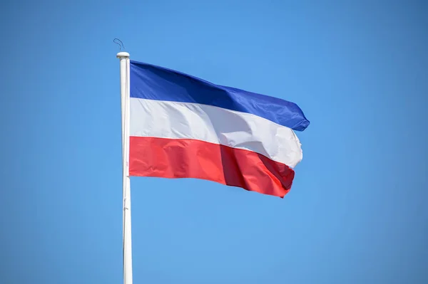 Vlajka Šlesvicko-Holštýnska, federální stát Německa, mávajících větrem proti modrému nebi, kopírovat prostor — Stock fotografie