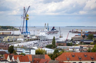 Wismar, Almanya, 28 Eylül 2019: Wismar deniz limanı ile feribot, yelkenli tekneler ve vinç yukarıdan bulutlu bir gökyüzü altında, St Georgen kilisesinin tepesinden havadan şehir manzarası görünümü, kopya uzay