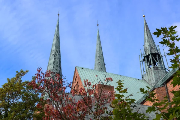 Toit, tours et tourelle de crête de la cathédrale de Luebeck, détail de l'église historique en brique contre un ciel bleu avec des nuages de plumes, espace de copie — Photo