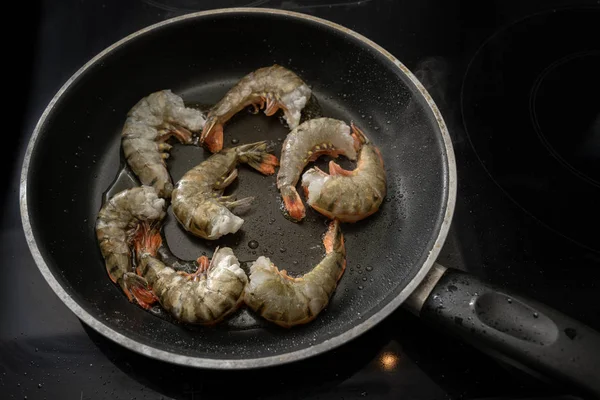 Sült nyers fekete tigris garnélarák kagylóval, de fej nélkül egy serpenyőben a tűzhelyen, főzés ízletes étel alacsony szénhidráttartalmú étrend — Stock Fotó