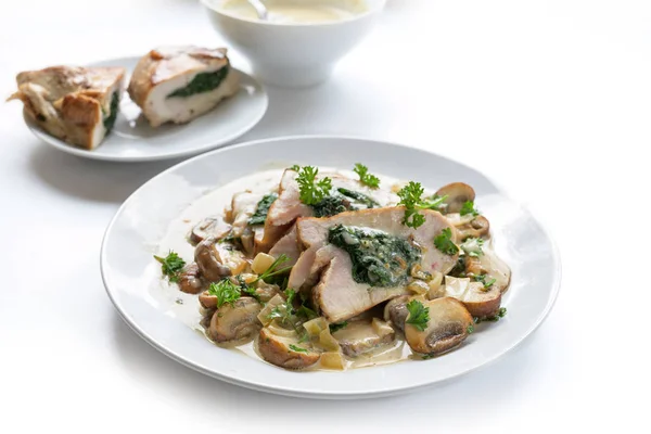 Filetto di petto di pollo farcito con ripieno di spinaci, servito con funghi, guarnire il prezzemolo e una salsa di gorgonzola cremosa, sfondo bianco con spazio per copiare — Foto Stock