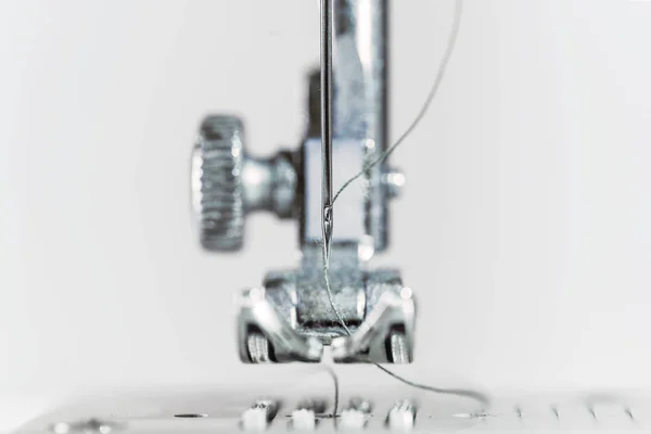 Nadel und Nähfuss einer Nähmaschine als extreme Makroaufnahme, technische Erfindung für die Bekleidungsindustrie, heller Hintergrund mit Kopierraum — Stockfoto