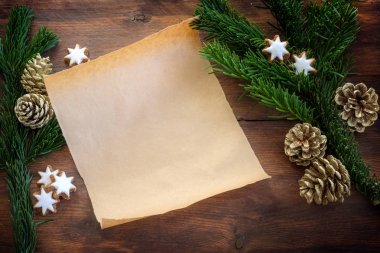 Köknar dalları, tarçın yıldızları ve yemek tarifi, alışveriş listesi için Noel süslemesi ya da karanlık ahşap bir masa üzerinde Noel Baba 'ya bir dilek mektubu, fotokopi alanı, yukarıdan üst görüş.