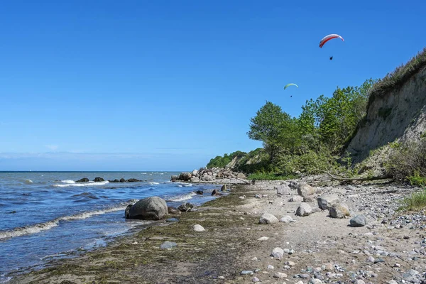 パラグライダーはバルト海の海岸の急な海岸を飛んでいます 屋外スポーツのための美しい風景 コピースペースを持つ青い空 — ストック写真