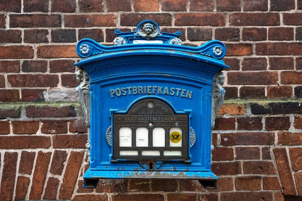 德国北部Elbe河畔Lauenburg的一座砖墙上挂着一个历史性的蓝色邮筒 它仍在使用中 现在已成为旅游胜地 选定的重点是狭窄的田野深度 — 图库照片