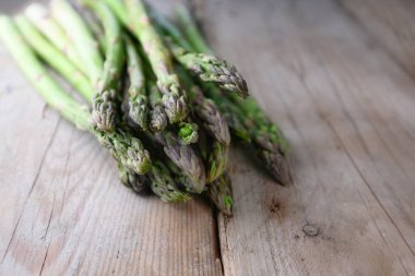 Kırsal ahşap bir masa üzerinde organik yeşil kuşkonmaz, kopyalama alanı, seçilmiş odak, dar alan derinliği