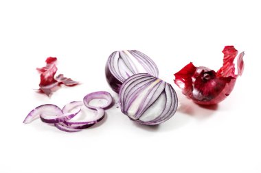 Taze soyulmuş kırmızı soğan kesimi ve beyaz arka planda küçük gölgelerle izole edilmiş dilimler, kopyalama alanı, seçilmiş odak, dar alan derinliği