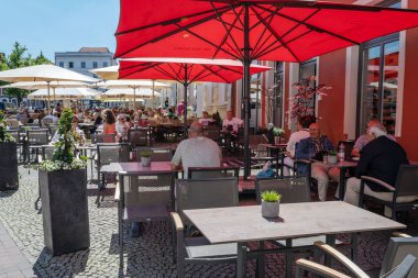 Wismar, Almanya, 15 Haziran 2020: İnsanlar Coronavirus salgını sırasında kitlendikten sonra pazar yerindeki bir sokak kafesinde güneşli bir yaz gününün tadını çıkarıyorlar.