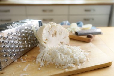 Sağlıklı düşük karbonhidratlı ya da ketojenik diyet öğününün yerine seçilmiş bir mutfak işyerinde, seçilmiş bir odak noktası ve dar bir alan derinliğinde rendelenmiş karnabahar.