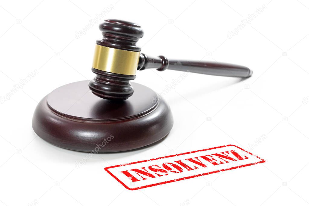 Judge gavel and a red stamp with the German word Insolvenz (meaning insolvency) isolated on a white background