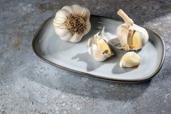 Σκόρδο Ένα Πιάτο Και Ένα Γκρίζο Πέτρινο Φόντο Υγιές Γαρύφαλλο — Φωτογραφία Αρχείου
