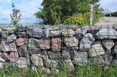 Gabionlar, tel kafeslerdeki taşlar, bahçelerde ve manzaralarda tahkimat ya da sınır duvarları olarak seçilmiş modern bir tasarım seçeneği.
