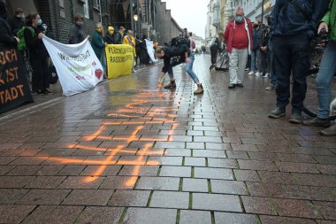 Lubeck, Almanya, 09 Eylül 2020: Protestocu, Lezbiyenler 'deki Yunan mülteci kampı Moria' da çıkan yangından sonra mültecilerin konaklaması için Lubeck 'te düzenlenen bir gösteride tahliye kelimesini sokağa püskürtüyor. 