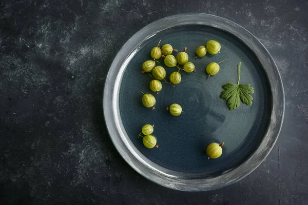 一些新鲜收获的有机山莓在深蓝色的盘子和深色的背景上 复制空间 从上方高角度的视野 — 图库照片