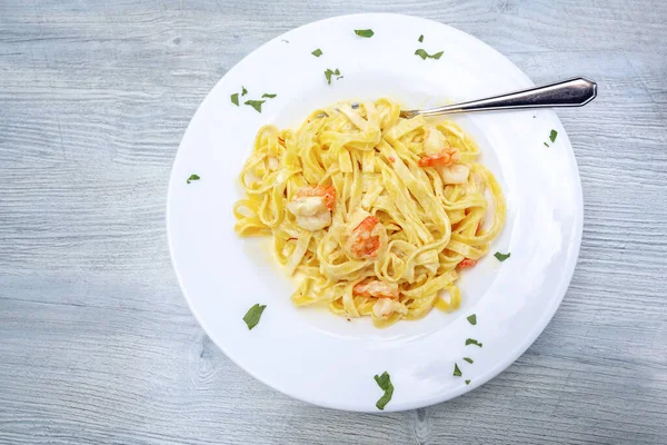 Pasta Tagliatelle Con Gambas Salsa Azafrán Plato Blanco Sobre Una — Foto de Stock