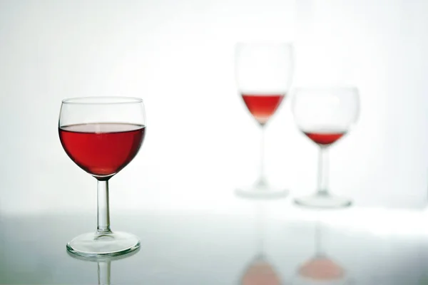 Szklanka Picia Czerwonym Winem Pierwszym Planie Jeszcze Dwa Zamazane Plecy — Zdjęcie stockowe