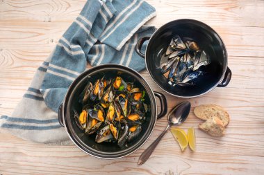 Tenceredeki midyeler ve kapaktaki boş kabuklar, ahşap masadaki limon, ekmek ve mavi havlu, kopyalama alanı, yukarıdan yüksek açı görünümü, seçilmiş odak noktası