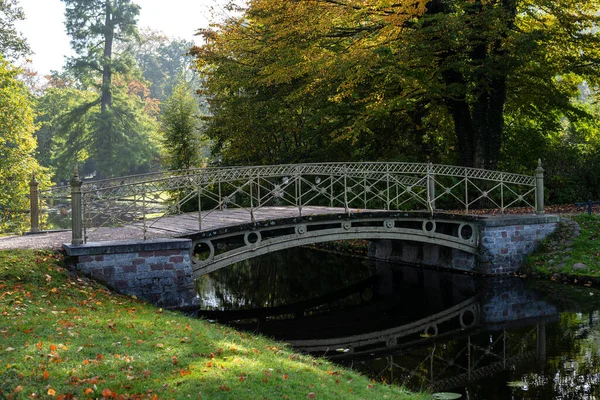 Pedestrian bridge over a canal in the park at the Schwerin castle on a sunny autumn day, copy space, selected focus, narrow depth of field