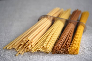 İçinde makarna bulunan bir ölçek spagetti. Kapatın. Yemek pişirmek. Metal mutfak aletleri. Toplu ölçü. Mutfak eşyaları.                                                                      