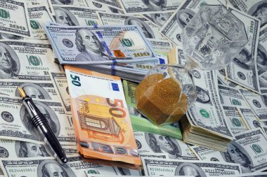 Vakit nakittir. Kum saati notaların üzerinde duruyor. Dolar.                               