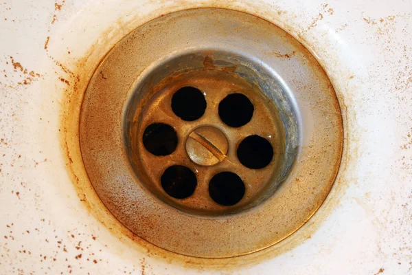 Rusty water in the sink. Hazardous tap water flows yellow.