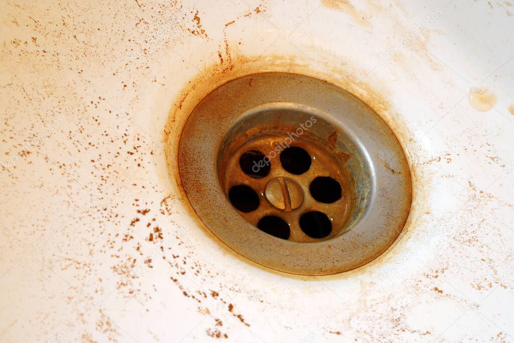 Rusty water in the sink. Hazardous tap water flows yellow.                               