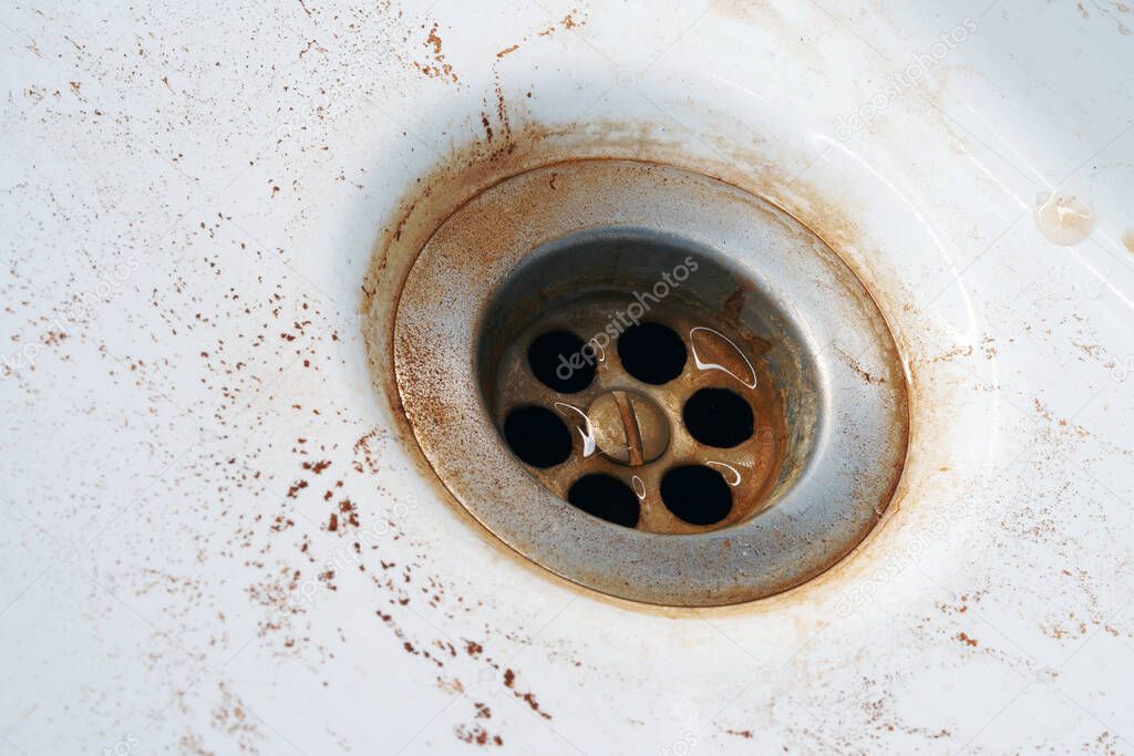 Rusty water in the sink. Hazardous tap water flows yellow.                               
