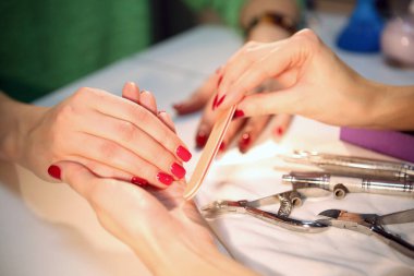 Kırmızı manikür. Güzellik salonunda el ve tırnak bakımı. Spa tedavisi