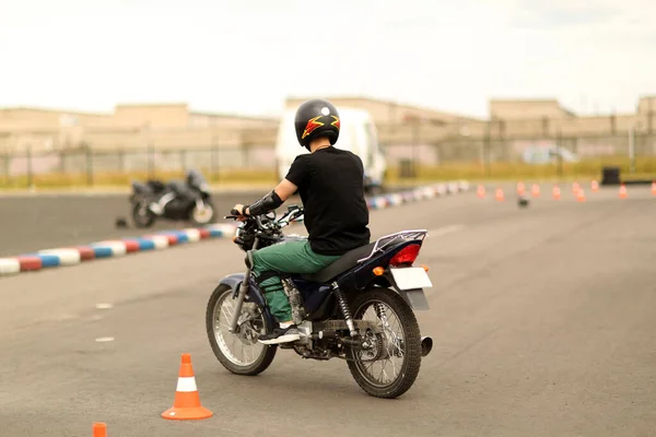 学校の運転のレッスン オートバイのバイク乗り 若い男はバイクの運転の仕方を学ぶ バイクを運転する人を助言する運転指導員 自動二輪車の手を閉じる開始 ロイヤリティフリーのストック画像