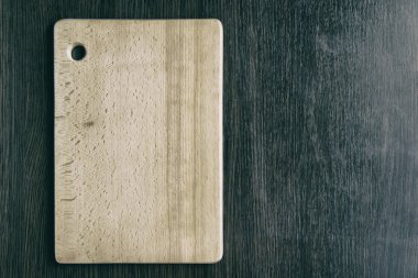 Koyu kahverengi ahşap masa arka plan üzerinde hafif sarı ahşap kesme kurulu yalan