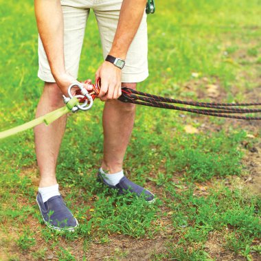 Adam bir ekipman düzeltmeleri hazırlar dağcılık veya slacklining için ip üzerinde kemer