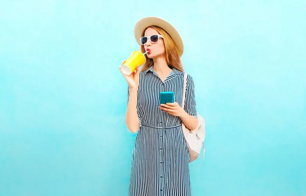 Modefrau Trinkt Fruchtsaft Aus Tasse Hält Smartphone Auf Blauem Hintergrund — Stockfoto