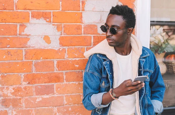 Mode Afrikaanse Man Bezit Smartphone Stad Straat Bakstenen Muur Achtergrond — Stockfoto