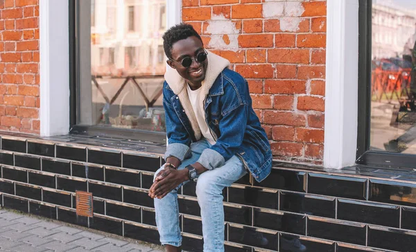 Mode Lächelnder Afrikanischer Mann Jeansjacke Sitzt Auf Der Straße Der — Stockfoto