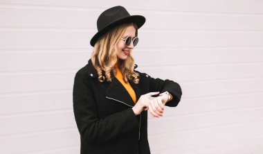 Genç gülümseyen kadın ses asistanı veya şehir, sokak, çağrı alır kullanarak akıllı bakarak portre gri duvar arka plan