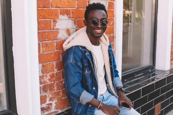 Mode Lächelnder Afrikanischer Mann Jeansjacke Sitzt Auf Der Straße Der — Stockfoto