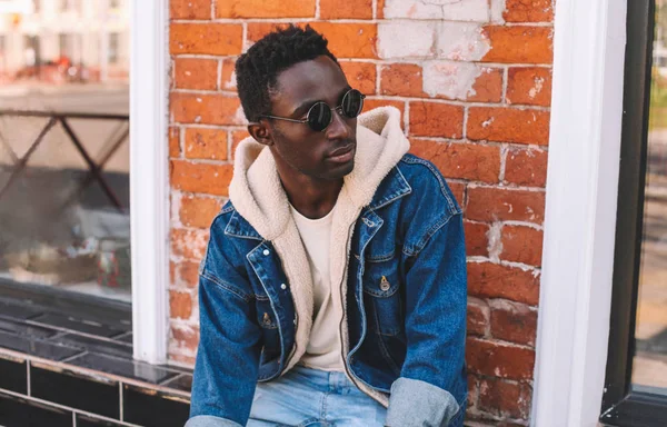 Modeporträt Afrikanischer Mann in Jeansjacke sitzt auf Zitat — Stockfoto