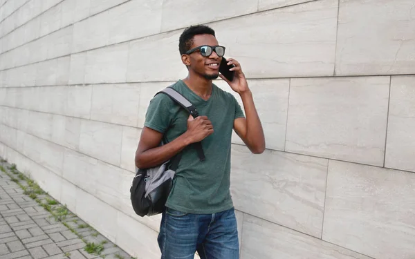 Portret gelukkig lachend Afrikaanse man opgeroepen smartphone wandelen — Stockfoto
