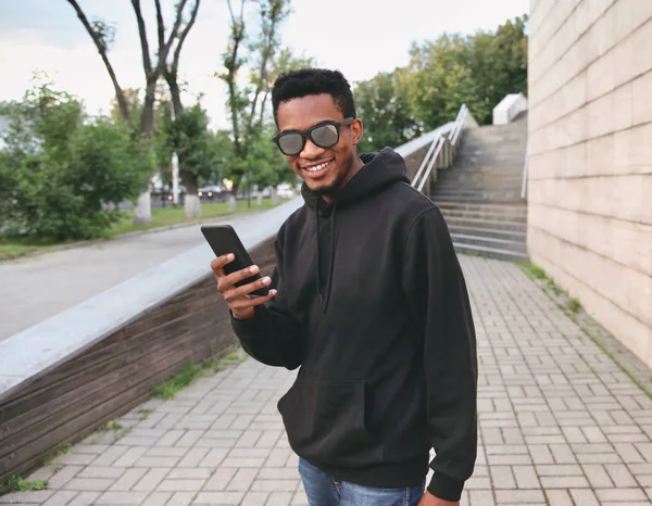 Πορτρέτο ευτυχής χαμογελαστοί Αφρικής άνδρας με τηλέφωνο σε μαύρο hoodie, s — Φωτογραφία Αρχείου