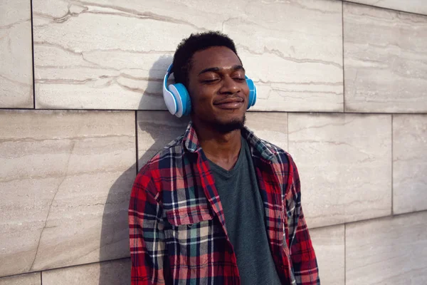 Retrato urbano sorridente homem africano em fones de ouvido sem fio enjoyi — Fotografia de Stock