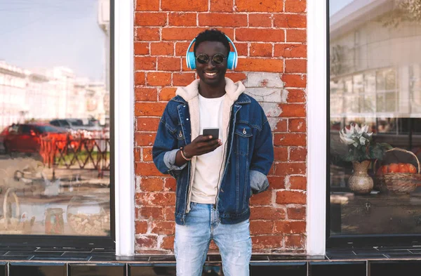スマート フォンの音楽を聴くことを使用してスタイリッシュな陽気なアフリカ人 — ストック写真