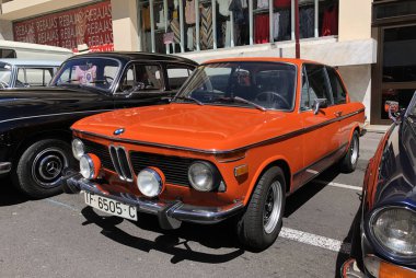 La Orotava, Tenerife, Spain - June 23, 2019: exhibition of classic and vintage cars, orange BMW 2002 car clipart